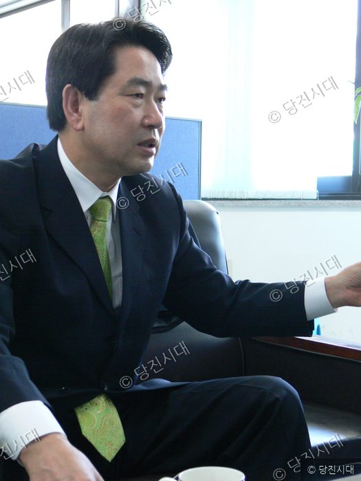 정장이 차림의 이덕연 의원이 소파에 앉아 이야기를 하고 있다.