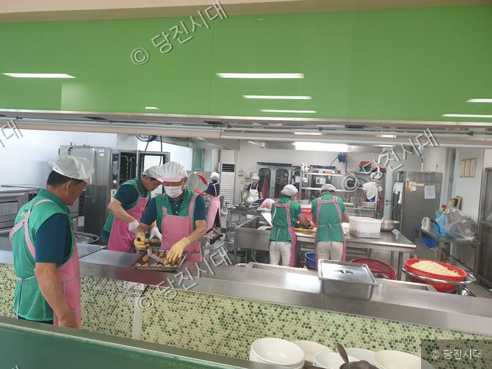 새마을운동 회원들이 단체로 급식실에서 조리 봉사 활동을 하고 있다.