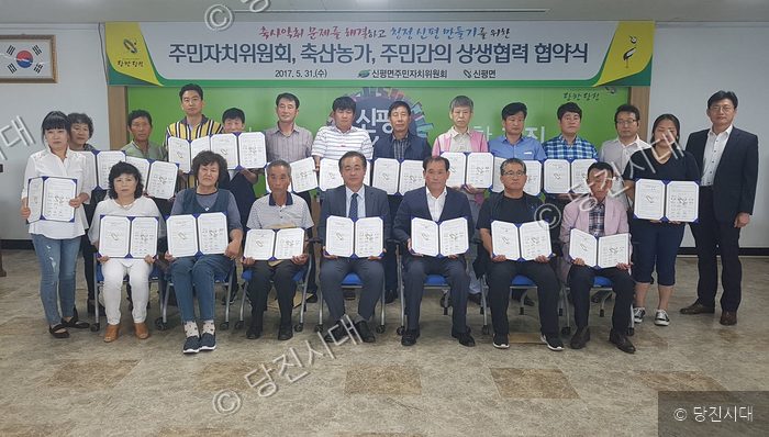 주민들이 상생협력 협약서를 들고 기념 촬영을 하고 있다.