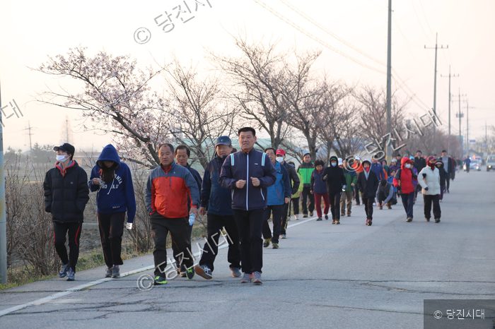 주민들이 우강 벚꽃길을 함께 걸으며 산책하고 있다.