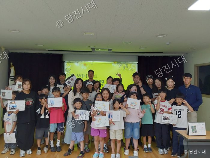 당진도서관에서 주민들이 가족과 함께 탁상달력을 만들고 기념촬영을 하고 있다.