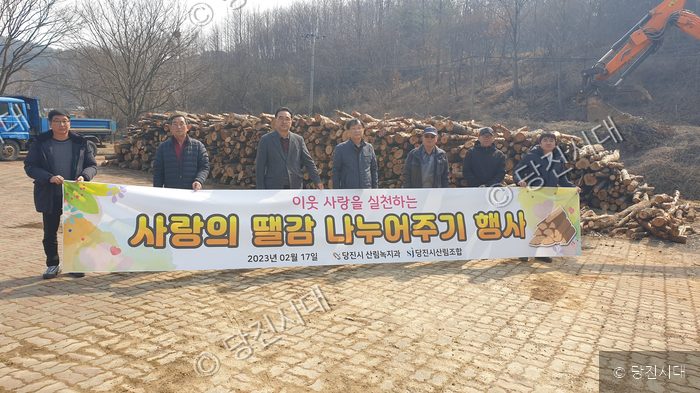 당진시 관계자들이 이웃사랑 뗄감 나누어주기 행사를 열고 기념 촬영을 하고 있다.