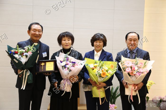 당진상공회의소 취임식에서 네 사람이 꽃다발을 들고 기념 촬영을 하고 있다.