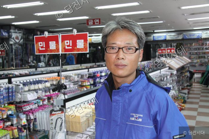 낚시용품 할인마트 대표가 매장에서 포즈를 취하고 있다.