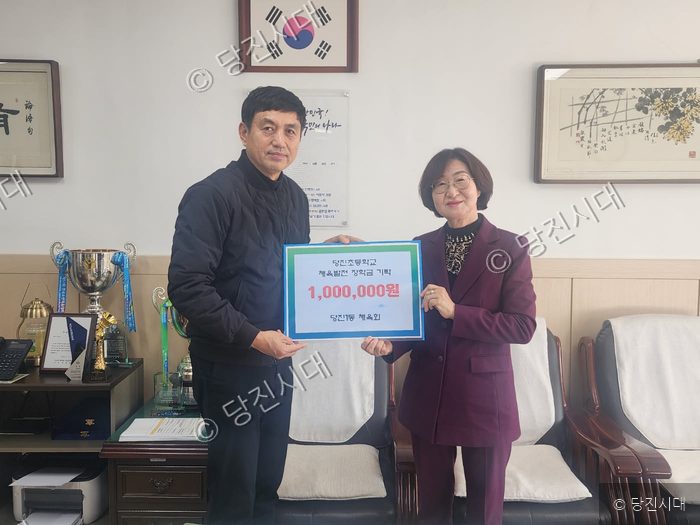 당진1동 체육회 최광일 회장이 당진초등학교에 체육발전 장학금을 전달하고 있다.