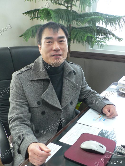 서해기술단 이종구 대표이사가 사무실 책상에 앉아 포즈를 취하고 있다.