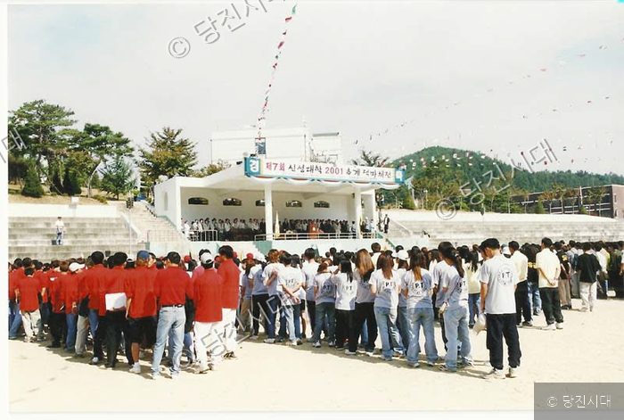 대학 운동장에서 대규모 체육대회 개회식이 열리고 있다.