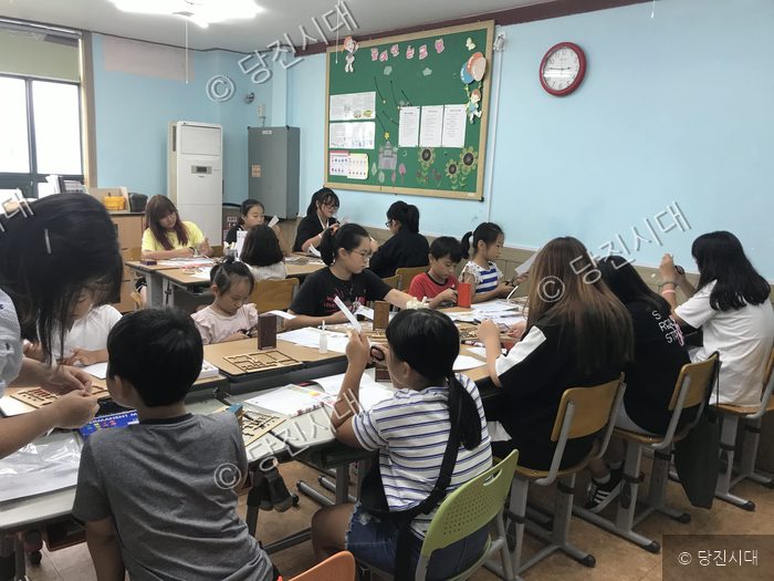 청소년들이 여름방학을 맞아 교실에서 만들기 체험을 하고 있다.
