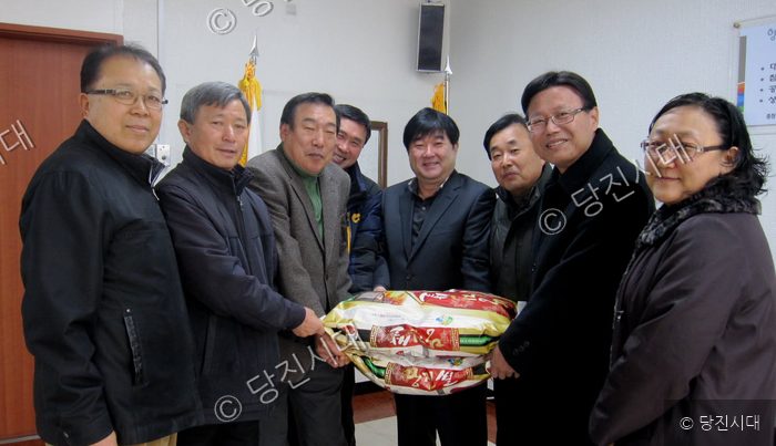 주민들이 연말연시를 맞아 쌀을 전달하며 기념 촬영을 하고 있다.