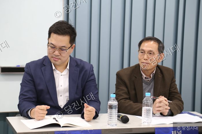 두 남성이 토론회 패널로 참석해 이야기를 나누고 있다.