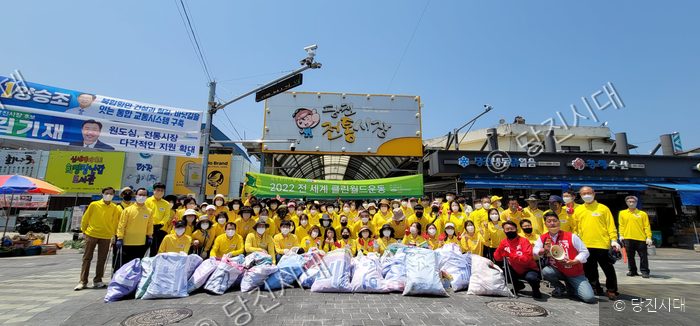 당진 전통시장 앞에서 봉사자들이 환경정화 활동 후 기념사진을 찍고 있다.