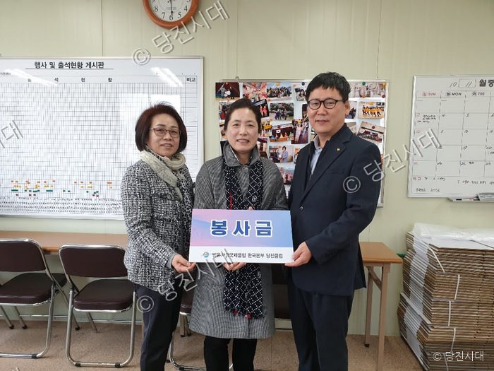 세 사람이 봉사금 피켓을 들고 기념 촬영을 하고 있다.