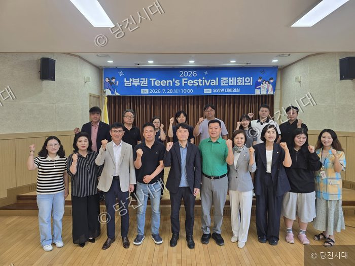 당진 지역 관계자들이 우강면 대회의실에서 2026 남부권 틴즈 페스티벌 준비회의를 열고 기념 촬영을 하고 있다.