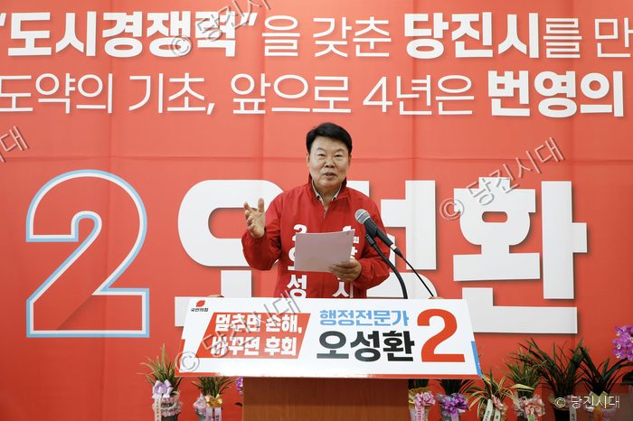 정치인 후보가 연단에서 공약을 발표하고 있다.