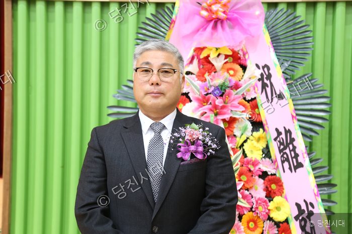 합덕읍 체육회장 취임식에서 전화춘 회장이 정장 차림으로 포즈를 취하고 있다.