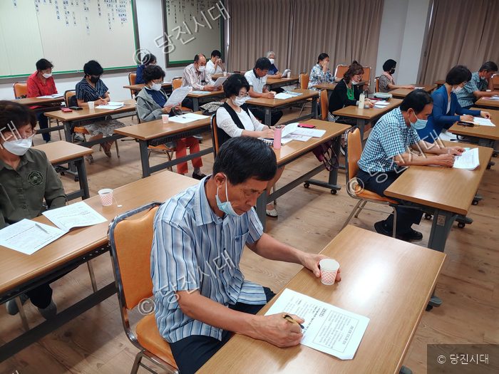 주민들이 교육장에서 새마을 관련 서류를 검토하고 있다.