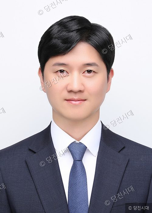안요진 더불어민주당 당진시의원 예비후보자가 정장 차림으로 정면을 바라보며 미소 짓고 있다.