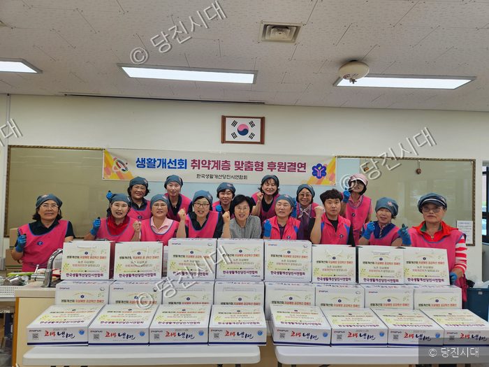 생활개선당진시연합회 회원들이 취약계층을 위한 후원 물품을 앞에 두고 기념 촬영을 하고 있다.
