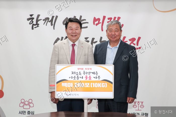 오성환 시장 등이 백미 기부 피켓을 들고 기념 촬영을 하고 있다.