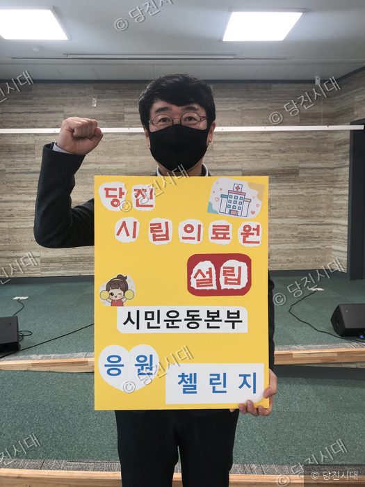 오동원 씨가 시립의료원 건립 촉구 릴레이 피켓을 들고 포즈를 취하고 있다.