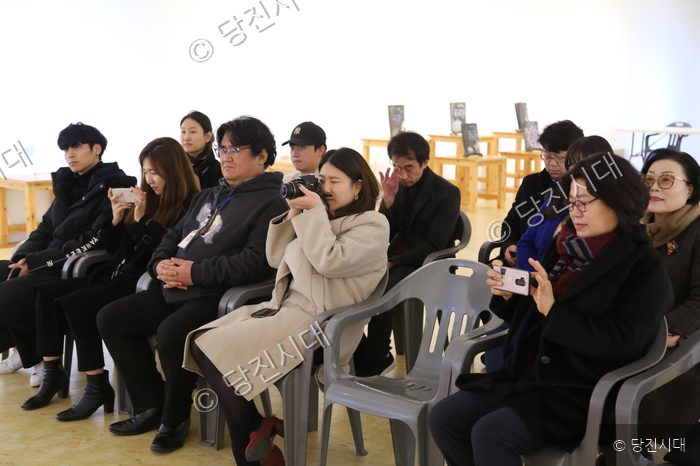 행사에 참석한 시민들이 강연을 경청하며 스마트폰과 카메라로 사진을 찍고 있다.