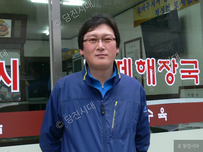 식당 앞에서 대표가 포즈를 취하고 있다.