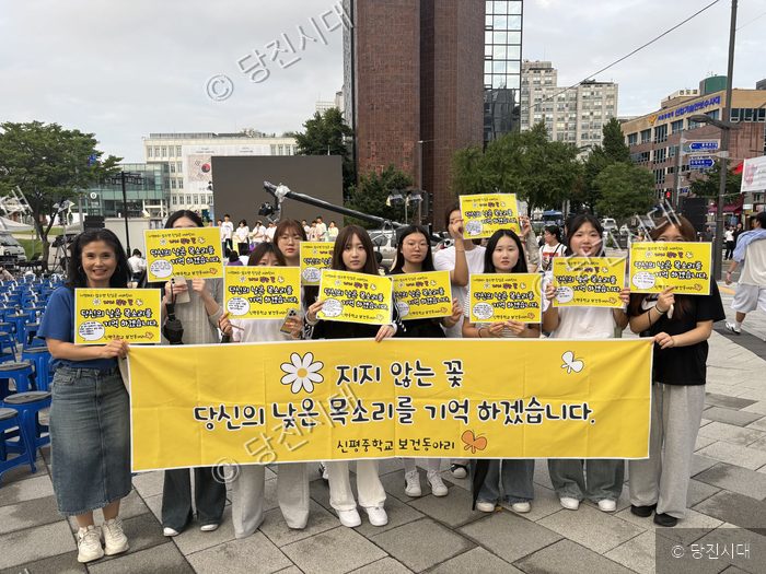 학생들과 류태환 교장 등이 나비 문화제에서 현수막과 피켓을 들고 있다.