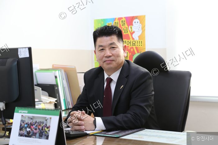 김형철 송악사회복지관장이 집무실 책상에 앉아 미소를 짓고 있다.