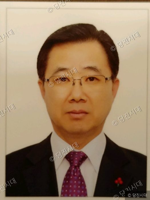 김덕연 씨가 정장 차림으로 정면을 바라보며 서 있다.