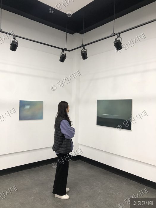 관람객이 갤러리에서 미술 작품을 감상하고 있다.