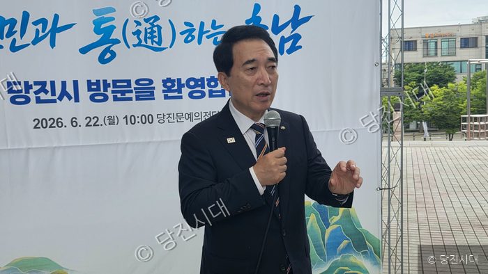 한 남성이 마이크를 잡고 당진문예의전당에서 열린 행사에서 발언하고 있다.
