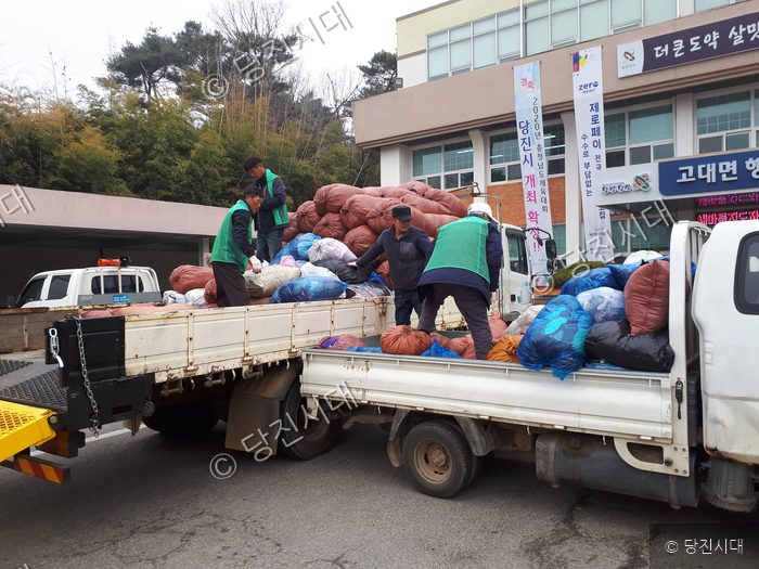 주민들이 트럭에 재활용품을 싣고 있다.