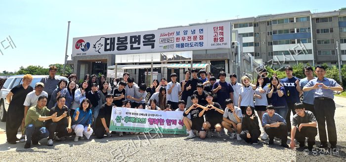 순성중학교 선후배들이 식당 앞에서 모여 기념 촬영을 하고 있다.
