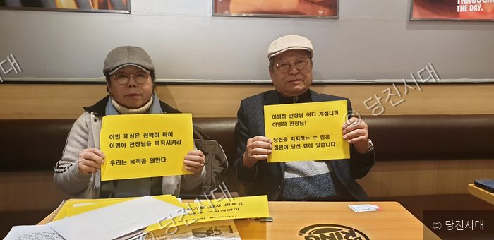 두 사람이 이병하 관장의 복직을 요구하는 피켓을 들고 있다.