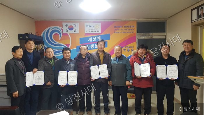로타리클럽 회원들이 임명장과 표창장을 들고 기념 촬영을 하고 있다.