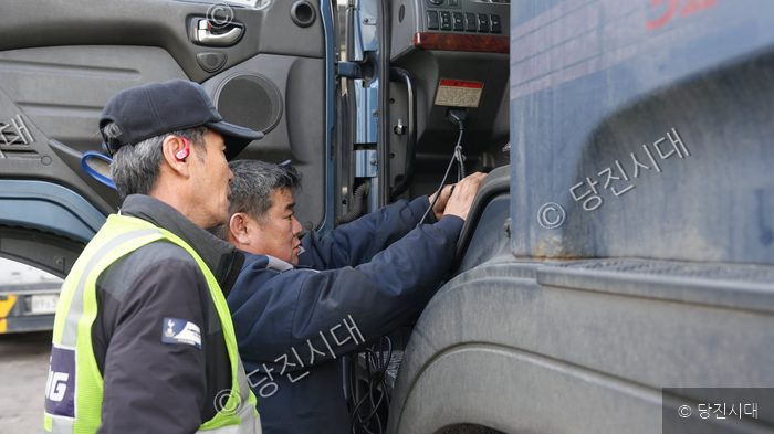 정비사들이 대형 화물차의 내부를 점검하고 있다.