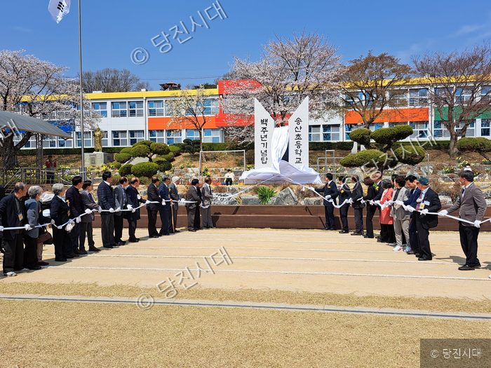 참석자들이 송산초등학교 백주년기념탑 제막식을 하고 있다.