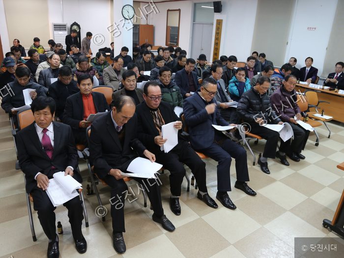 석문면 개발위원회 관계자들이 회의실에 모여 앉아 문서를 보고 있다.