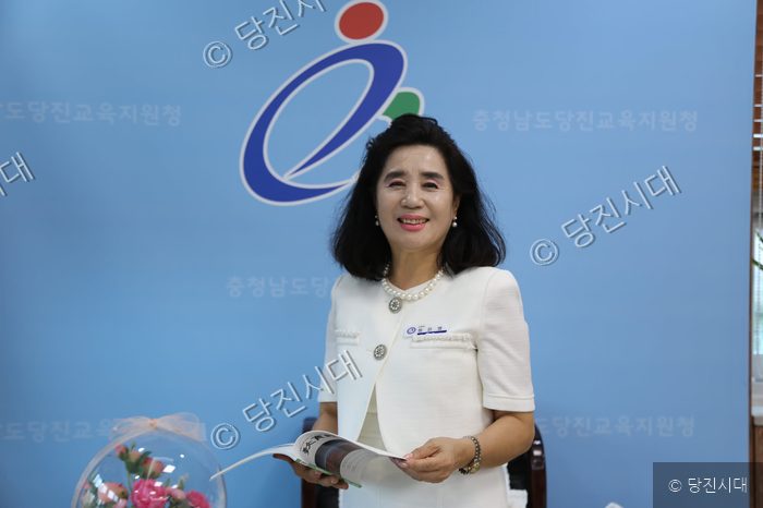 정은영 당진교육지원청 교육장이 인터뷰 중 책자를 들고 포즈를 취하고 있다.