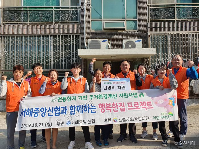 봉사자들이 주거환경 개선 사업 현장에서 기념촬영을 하고 있다.