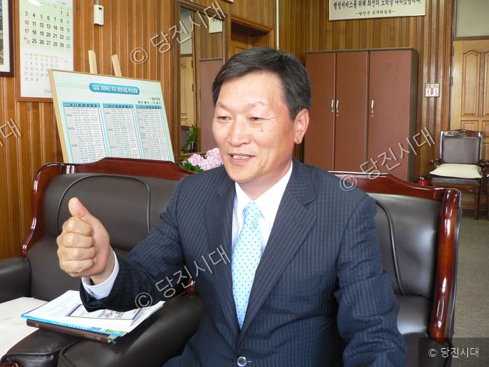 박성진 당진군 부군수가 집무실 소파에 앉아 엄지손가락을 치켜세우고 있다.