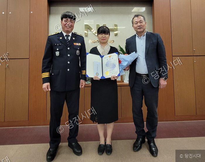 합덕농협 이정옥 대리가 경찰로부터 보이스피싱 예방 감사장을 받고 있다.