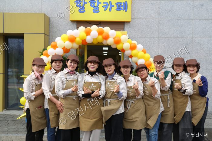 할할카페 운영자들이 카페 앞에서 환하게 웃으며 포즈를 취하고 있다.