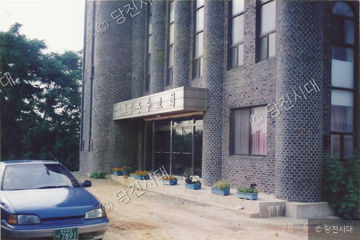 온수교회 건물의 전경과 앞에 주차된 차량의 모습이다.