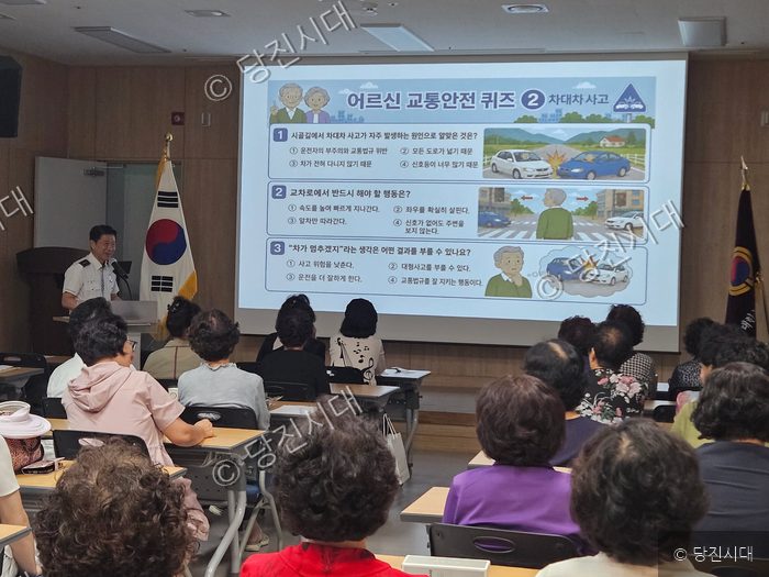 경찰관이 노인들을 대상으로 교통안전 교육을 진행하고 있다.