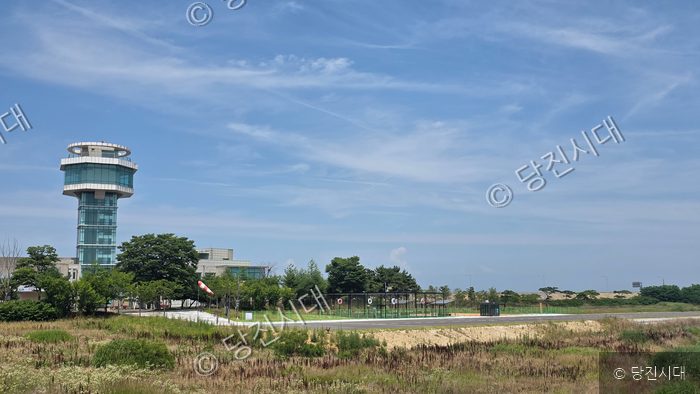 당진의 한 드론공원 시설물과 관제탑으로 추정되는 건물이 푸른 하늘 아래 서 있다.