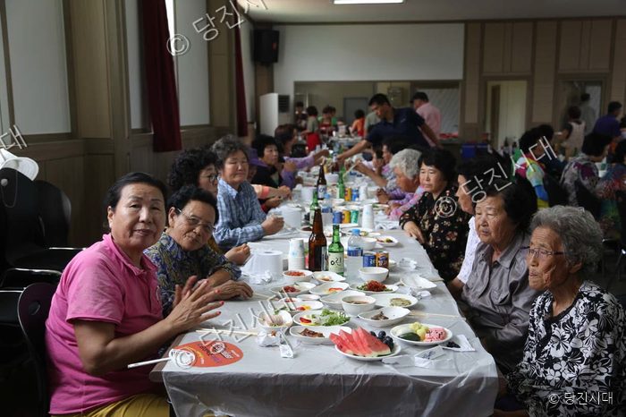 어르신들이 마을 경로잔치에 모여 식사를 하고 있다.