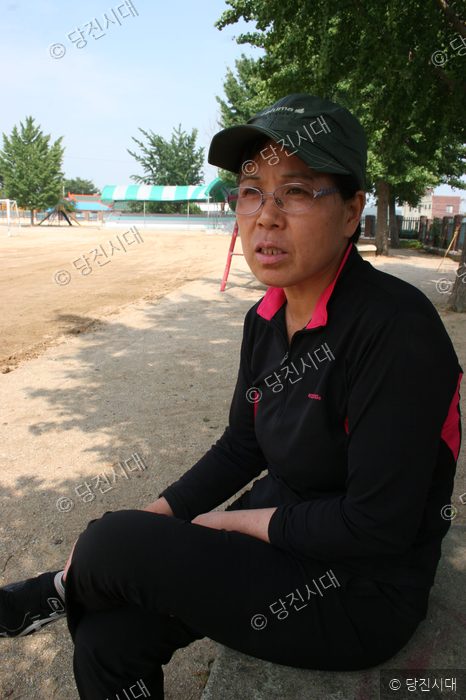 윤혜경 씨가 야외 운동장에 앉아 인터뷰를 하고 있다.