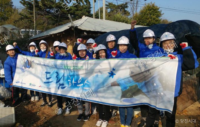 고치기 씨 등이 드림하우스 현수막을 들고 기념 촬영을 하고 있다.