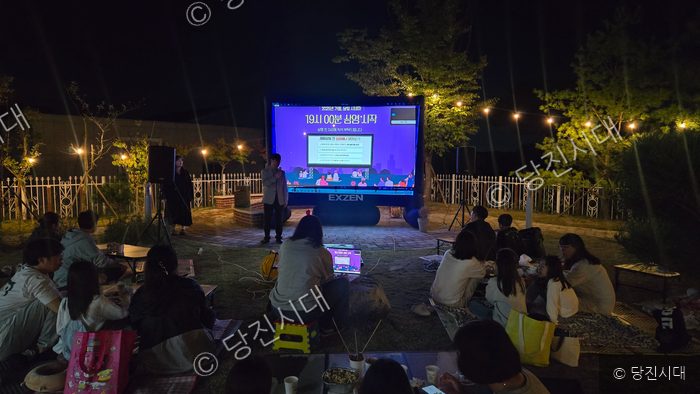 김수진 관장 등이 야외에서 대형 스크린으로 영화 상영을 기다리고 있다.